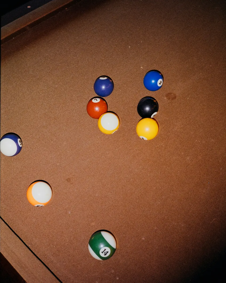 Pool balls scattered on warm surface.