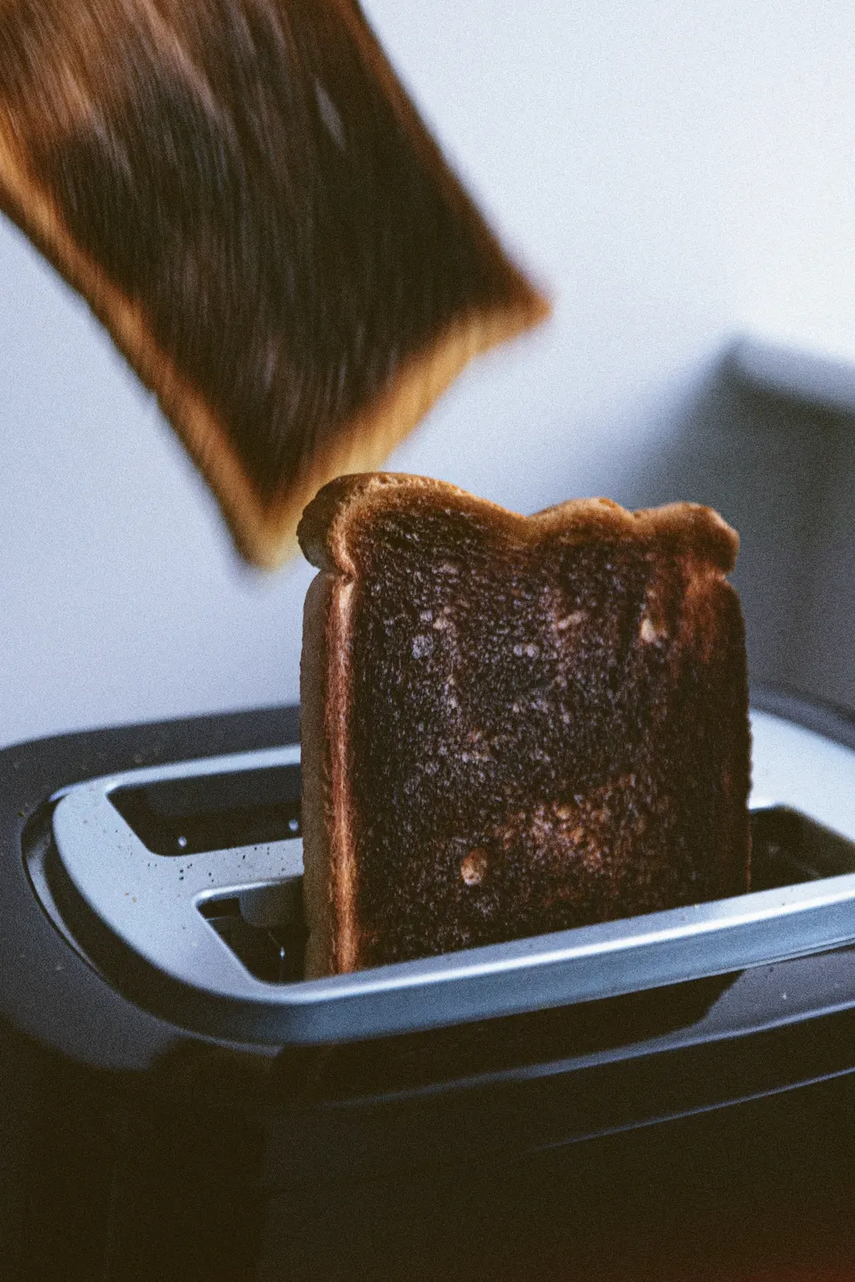 Toast popping from a toaster in warm light.