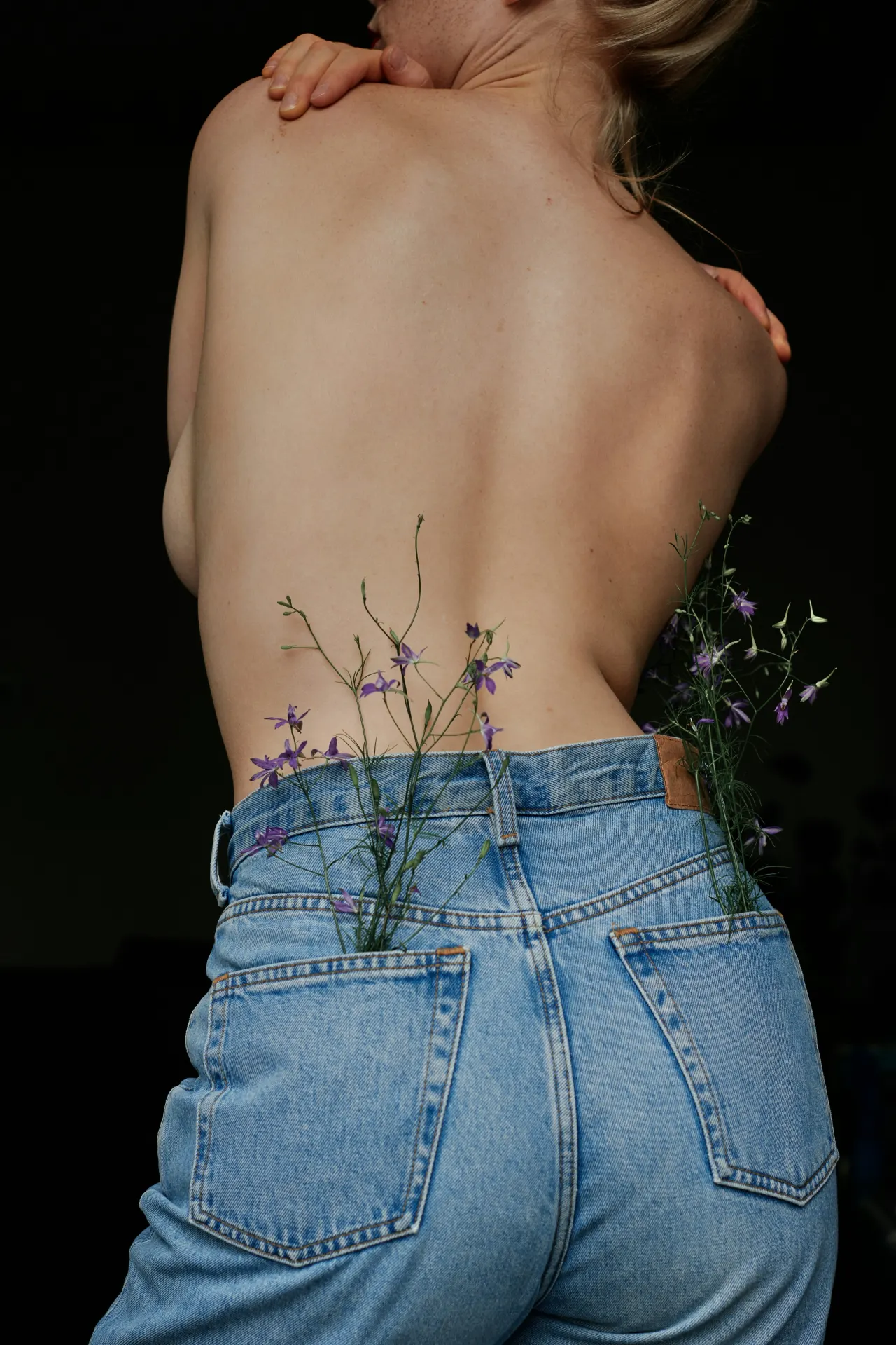 Back portrait with wild stems tucked into denim.